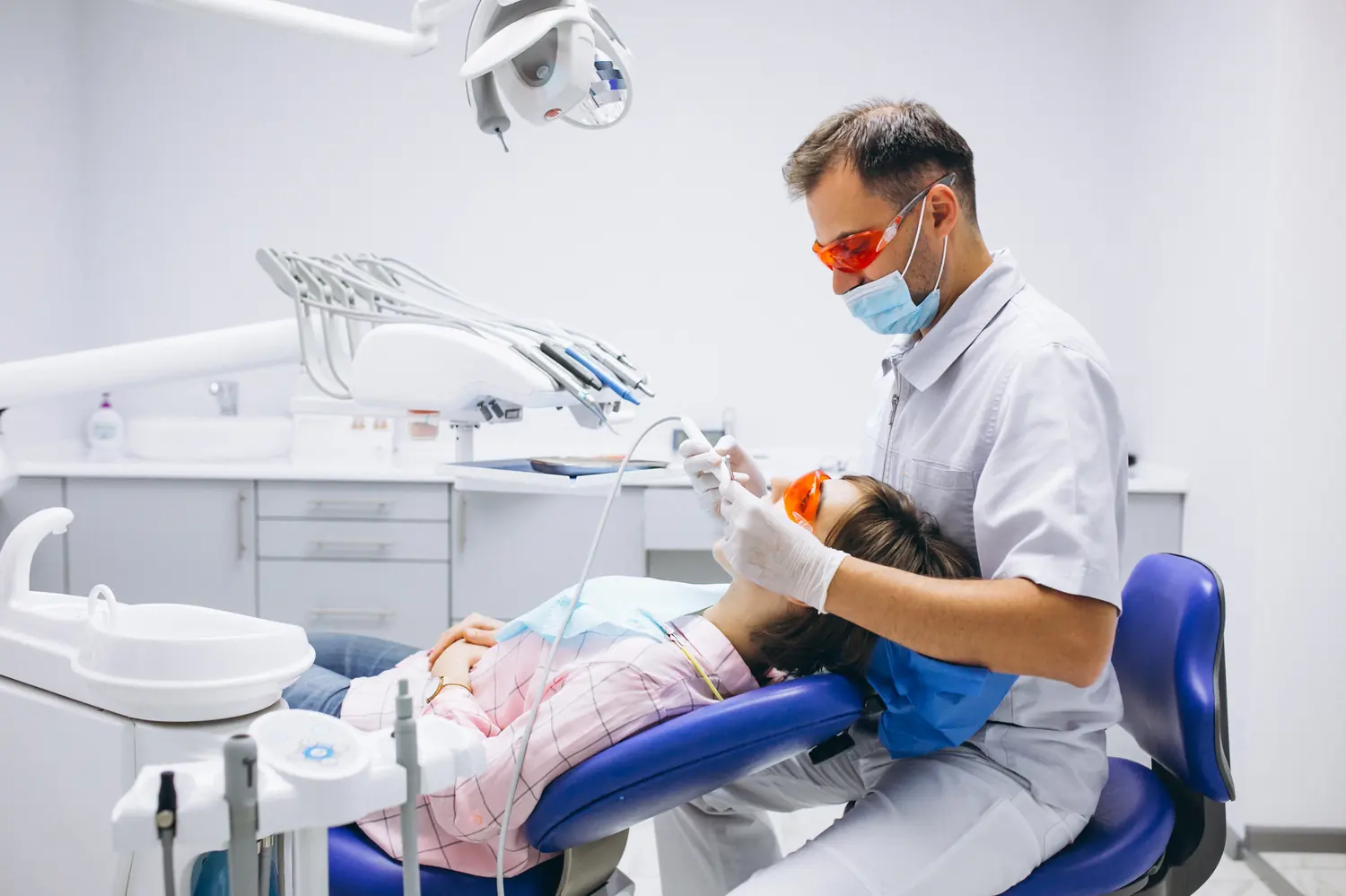 Dentista atendiendo a una paciente en el sillón dental